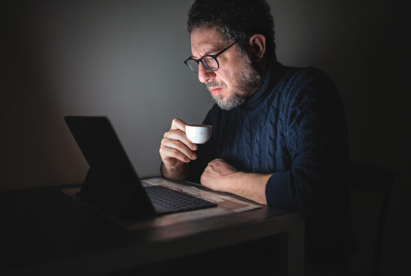 man looking at laptop in the dark
