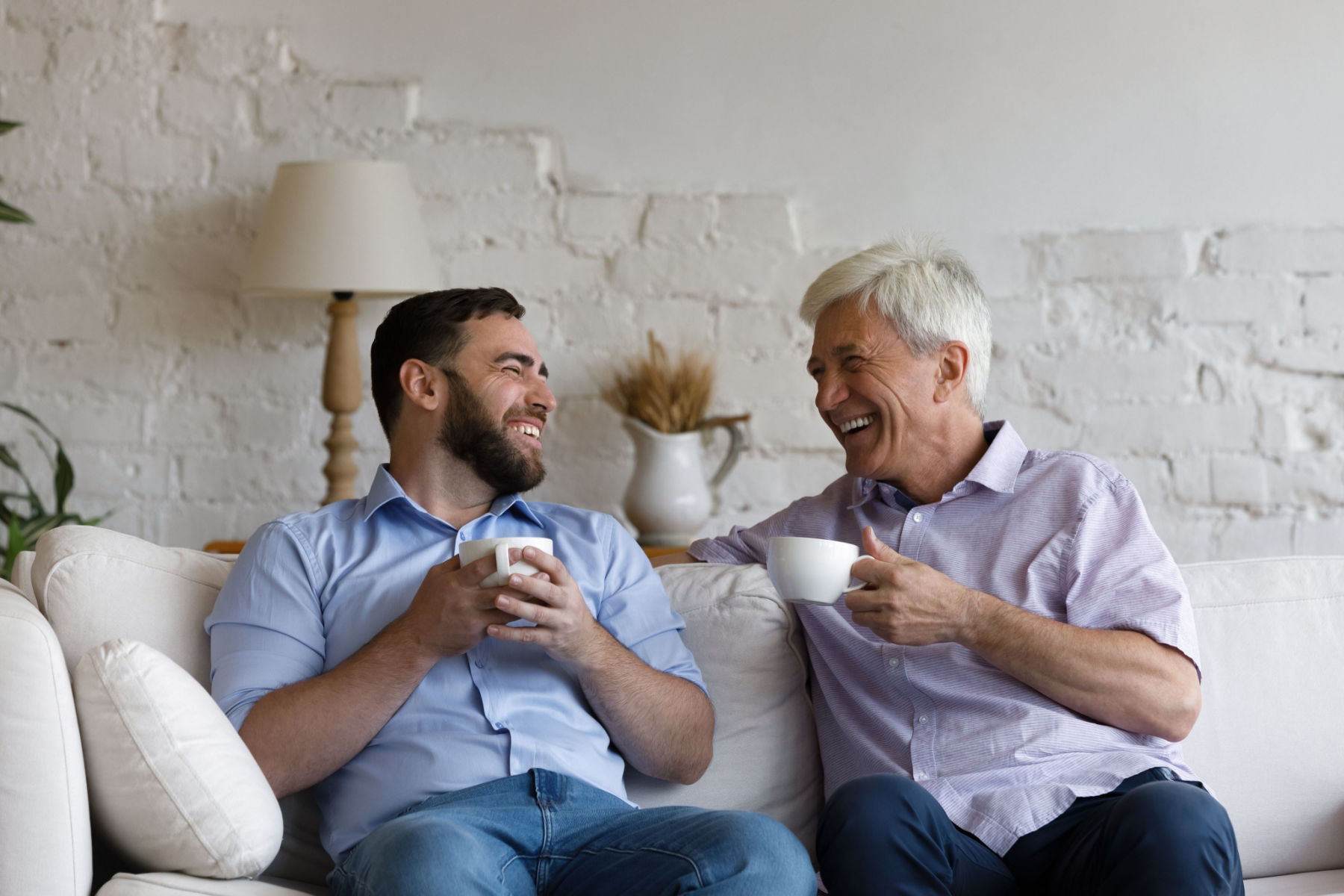 young man having cheerful discussion with older father