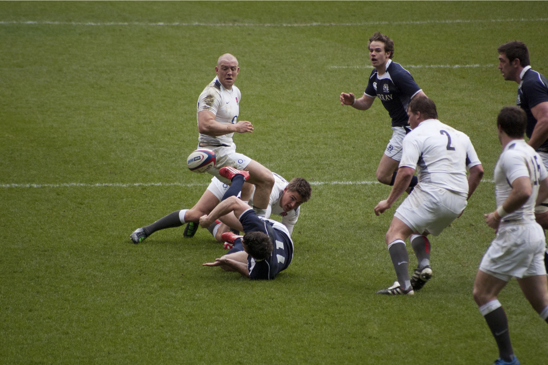 rugby player fumbles a ball during a match
