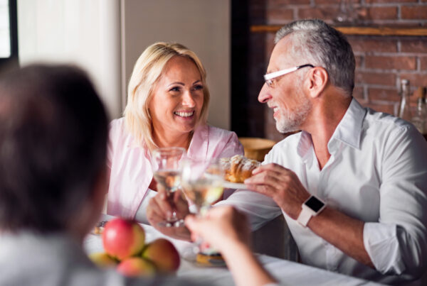 Middle-aged couple enjoying dinner and drinks with friends