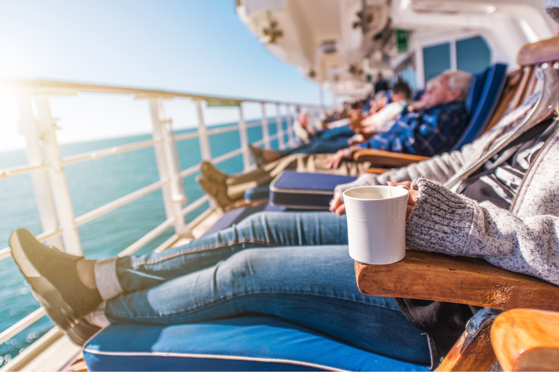People relax in deck chairs on a cruise
